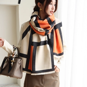 Detail view of thick geometric color-block scarf with short fringes on a model