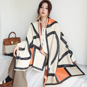 Detail of soft geometric cashmere scarf with bold orange blocks and fringe trim