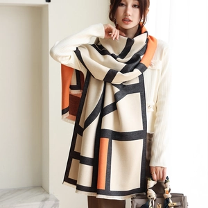 Detail view of thick geometric cashmere-like shawl with orange and black color blocks