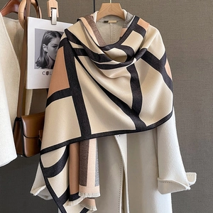 Close-up of thick geometric shawl with tassels, showcasing beige and brown cashmere texture