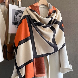 Thick geometric block color cashmere scarf shawl with tassels on a white coat display