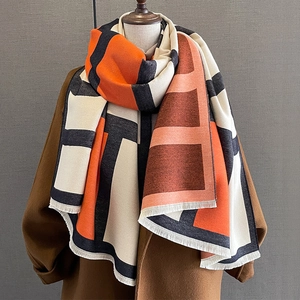 Detailed view of the geometric color block pattern and fine tassels on the thick shawl scarf