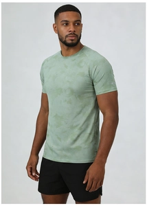 Detail of sage green breathable t-shirt fabric and black athletic shorts on a model