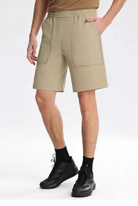 Dettaglio laterale di pantaloncini sportivi kaki da uomo con vita elastica e grandi tasche