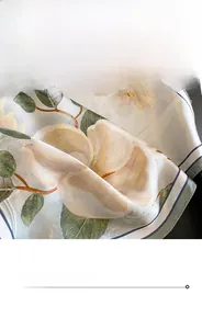 Close-up of fine hemmed edges and camellia floral print on silk square scarf