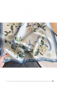 Primo piano dettagliato che mostra la cucitura fine di un foulard di seta avorio con fiori