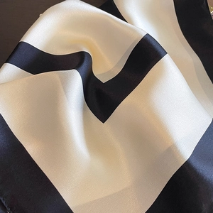 Elegante sciarpa in seta con motivo geometrico bianco e nero e finitura lucida satinata