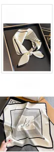 Detail of silk square scarf with black stripes and letter N print on satin fabric