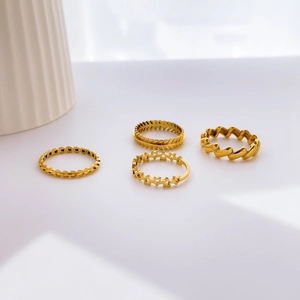 Set of four gold minimalist rings featuring olive leaf, star, and chain designs