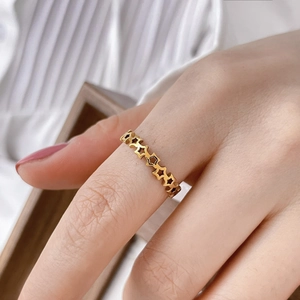 Detailed view of a gold-plated ring with a minimalist hollow star chain pattern design