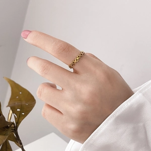 Close-up of a minimalist gold hollow star ring worn on finger with olive leaf accents