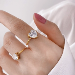 Elegante anello a cuore in oro con pietre di zircone viola e verdi sulla mano