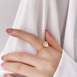 Dettaglio dell'anello con cristallo a cuore dorato indossato sul dito indice