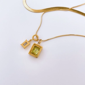 Details einer goldenen Schlangenkette mit rechteckigem Zirkonia- und Achat-Anhänger