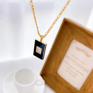 Detailansicht eines quadratischen schwarzen Achat-Anhängers mit Zirkon an Goldkette