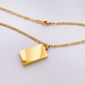 Detail einer 18K Gold Figaro-Halskette mit Rechteck-Anhänger und K18-Stempelung