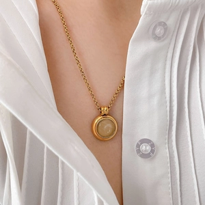 Détail du collier en titane plaqué or 18 carats avec pierre œil-de-chat sur chemise blanche