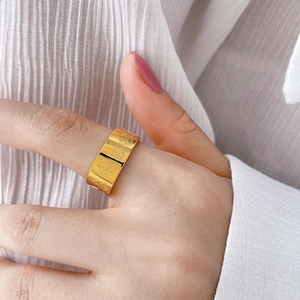Exaggerated gold ring for women featuring intricate floral relief carvings on a wide band