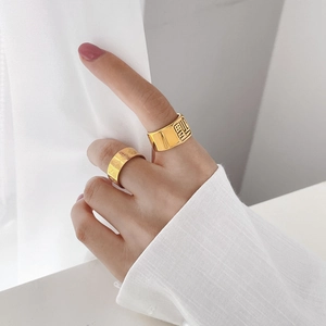 Macro view of gold-toned rings with Chinese character Fu and retro floral engraving