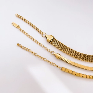 Detailed macro of vintage gold geometric square beads and fish scale chain texture