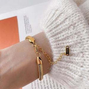 Close-up of golden fish scale mesh bracelet with K18 tag and lobster clasp detail