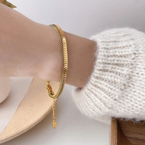 Vintage gold fish scale chain bracelet with square beads on wrist in minimalist setting