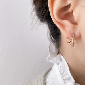 Close-up of gold pavé zircon hoop earrings on ear showing delicate sparkle and detail