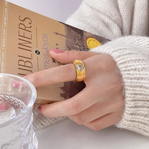 Minimalist gold wide band ring with round zircon inlay shown in a lifestyle setting