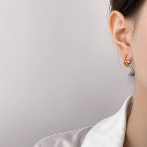 Minimalist double-layered gold hoop earrings with beaded tassels on an elegant model