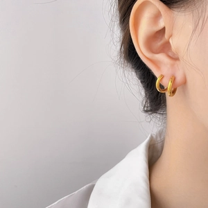 Minimalist double-layered gold hoop earrings with hammered texture on female model