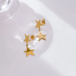 Close-up of golden double star earrings featuring polished stainless steel finish