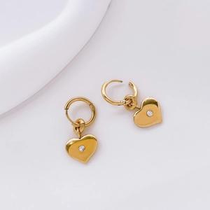 Detail of gold heart hoop earrings featuring a small central sparkling zircon stone