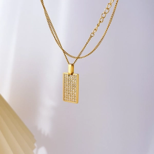 Close-up of golden rectangular checkerboard pendant with pave-set zircon stones