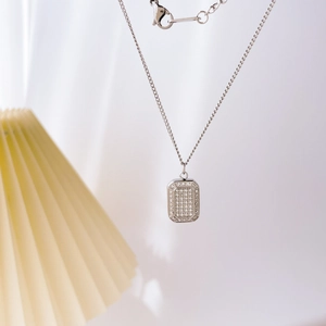 Detail of silver checkerboard pendant with cubic zirconia on a delicate link chain