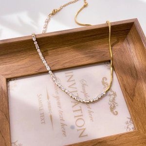 Detail of 18K gold plated snake chain necklace with rectangular cubic zirconia accents