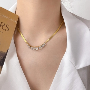 Close-up of 18K gold plated snake bone chain necklace with five square zircon stones
