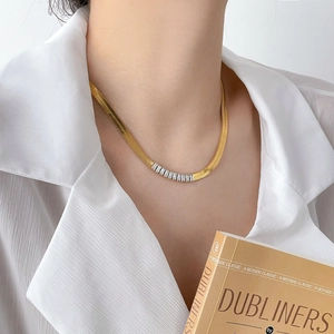 Detail of 18K gold-plated herringbone necklace with square zircon inlay on a model