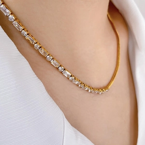 Detail of 18K gold snake chain and sparkling zircon tennis necklace on neck