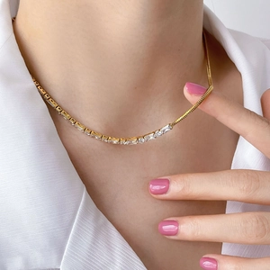 Macro view of gold-plated snake chain necklace with rectangular cubic zirconia accents