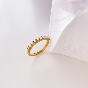 Détail macro d'une bague en titane plaqué or 18K ornée d'une rangée de perles blanches