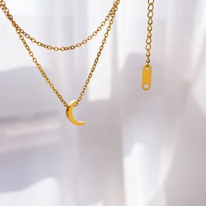 Detailed close-up of double-layer gold snake chain featuring a crescent moon pendant