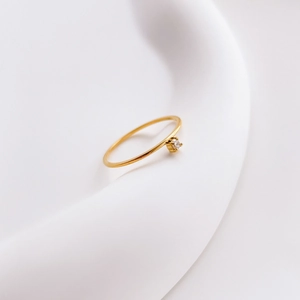 Gros plan sur la bague plaquée or 18K avec zircon carré serti à quatre griffes