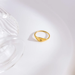 Détail d'une bague chevalière plaquée or 18 carats avec zircon et motif étoile