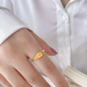Détail macro de bague en acier titane doré avec motif olive et insert en zircone