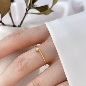 Détail d'une bague minimaliste plaquée or 18K avec zircon serti sur un anneau fin