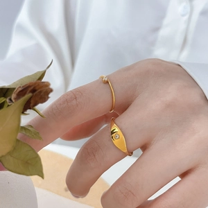 Détail de bagues en titane plaqué or 18 carats avec zircon carré et design étoile décalé