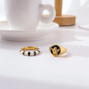 Exaggerated angel relief seal ring with black enamel and zebra striped gold ring set