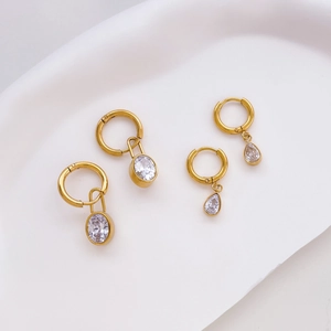 Gold oval and teardrop zircon earring set on minimalist white wavy tray for women