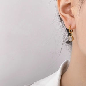 Close-up of gold drop earrings with sparkling clear cubic zirconia on female model