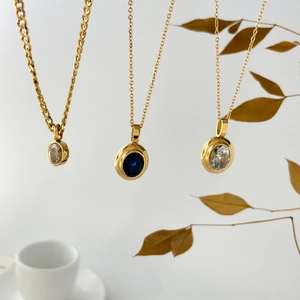 Golden necklaces featuring oval blue sapphire and clear zircon pendants on elegant chains